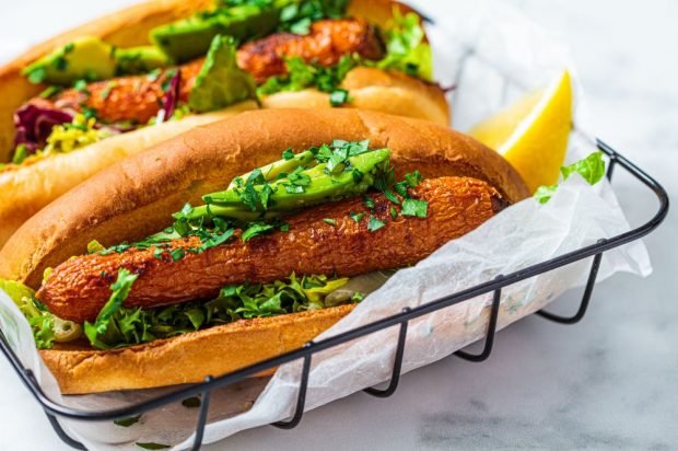 Vegetarian hot dog with baked carrots, oyster mushrooms and avocado