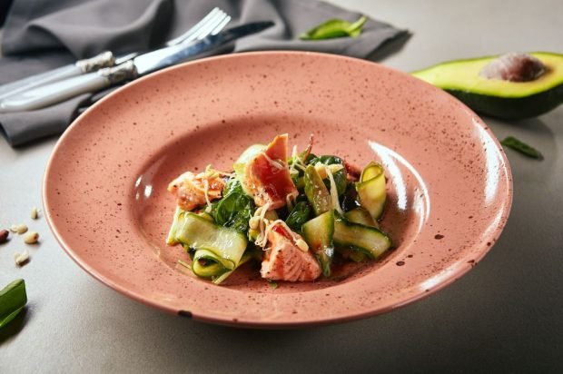 Spicy salad with avocado, spinach and fried red fish