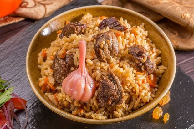 Meat pilaf with pickled garlic in a slow cooker is a simple and delicious recipe, how to cook step by step